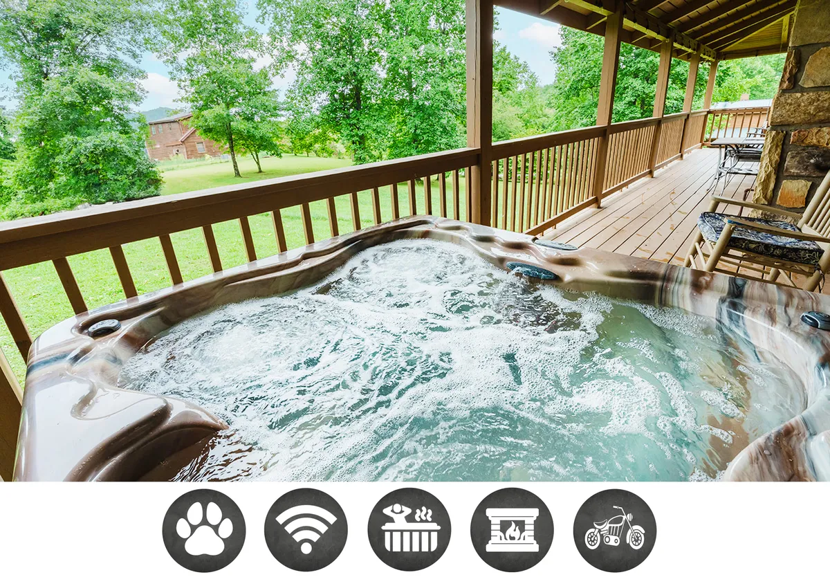 The hero image displays the cabin’s spacious deck nestled in lush greenery, with a steaming hot tub overlooking the tranquil Smoky Mountains. The sun sets in the background, creating a serene and inviting atmosphere perfect for relaxation and gatherings.